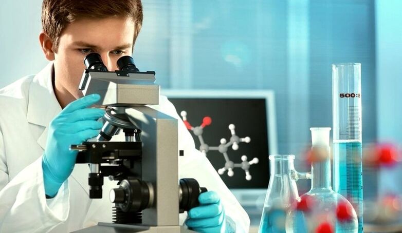 a specialist examines the material under a microscope